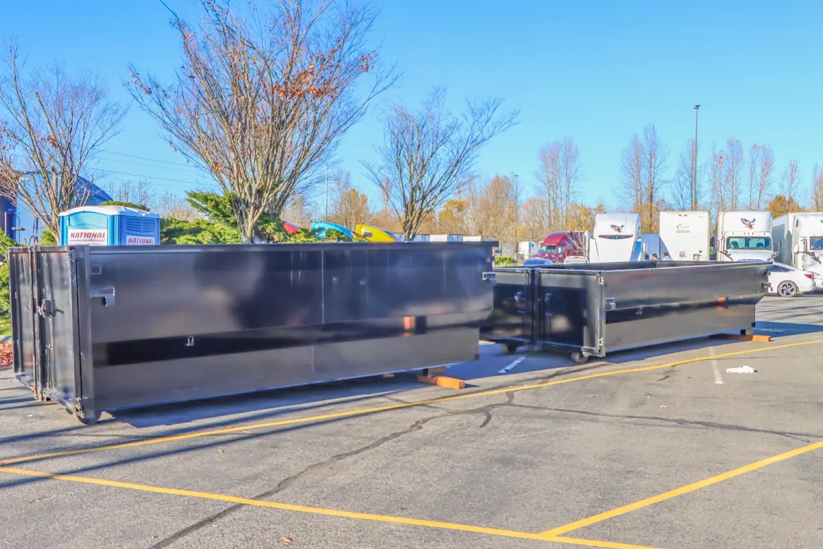 Professional dumpster rental service with roll-off container on residential driveway in Lakes of the Four Seasons